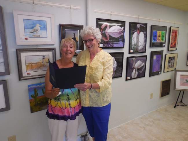 Linda Gebhart (left) shows off some of the gallery's art work