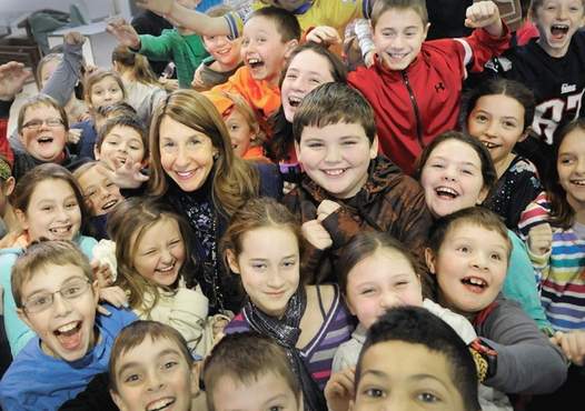 Lois Costa surrounded by 4th graders