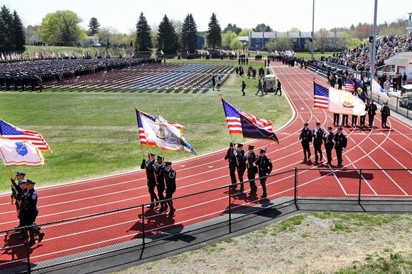 Police mourners march onto the field at Winnacunnet HS